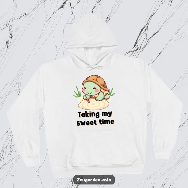 Funny Turtle Zen Hoodie: A tiny turtle smiles contentedly while raking a zen pattern in sand, offering cozy, humorous relaxation.